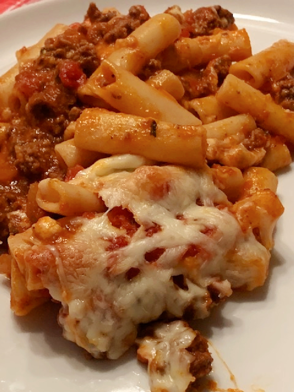 A serving of baked ziti on a white plate.