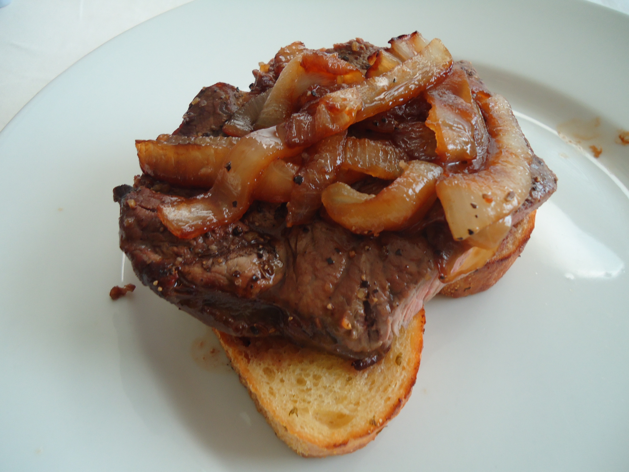 Open-faced steak and onions on garlic toast