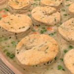 Chicken and biscuits in a baking dish.