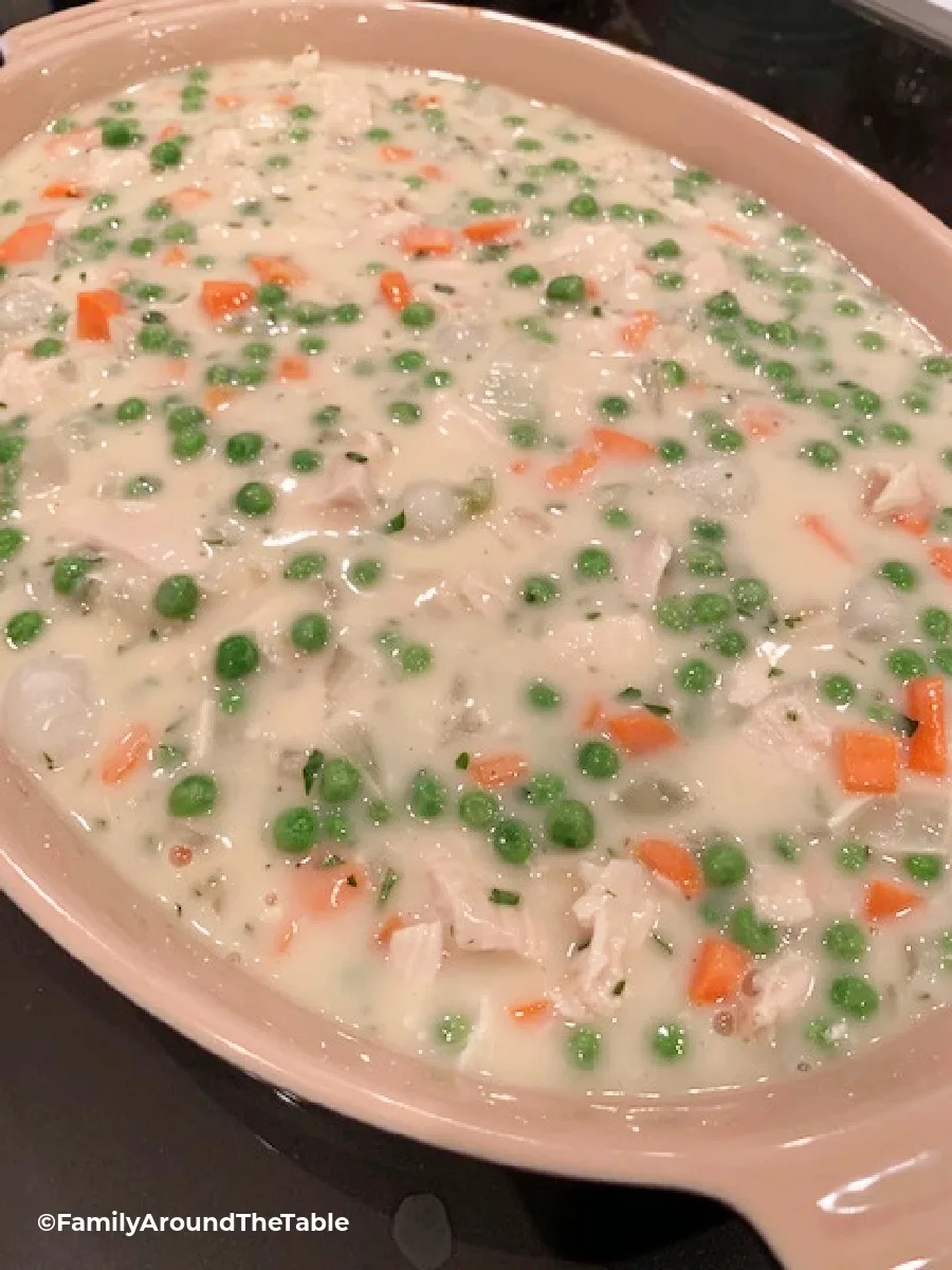 Creamy chicken and vegetable filling in a baking dish.