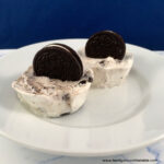 Oreo cookies and cream cups on a plate.