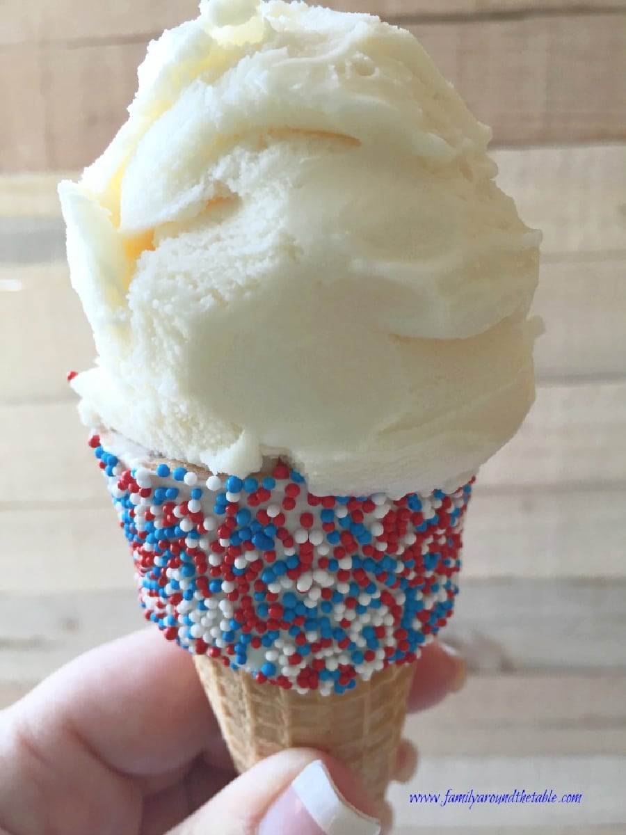 A vanilla ice cream cone decorated with red, white, and blue nonpareils.