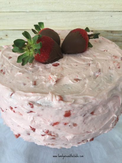 Whole Strawberry Layer Cake with Strawberry Buttercream garnished with 3 chocolate dipped strawberries.