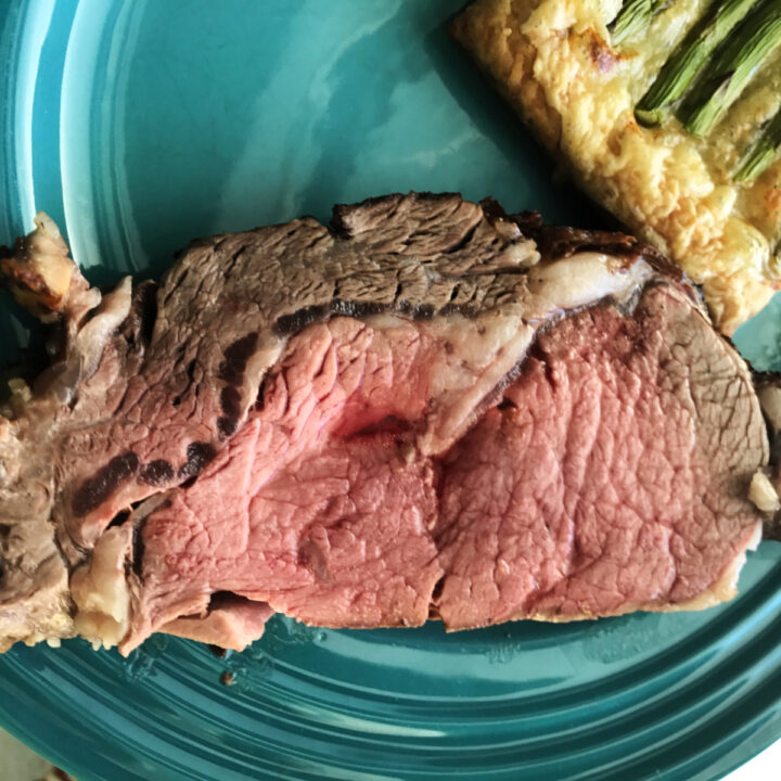 A slice of prime rib on a blue plate.