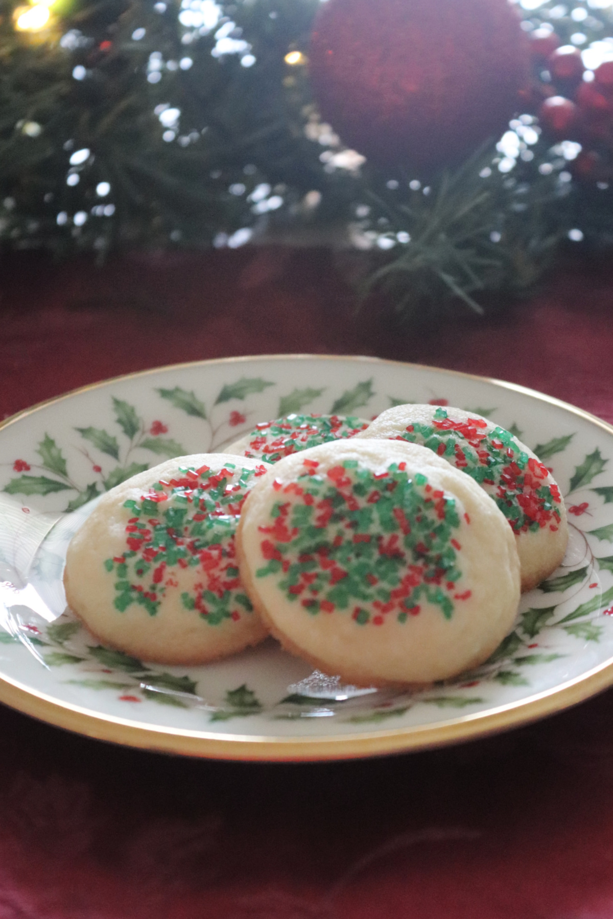  Four Sugar Sprinkled Butter Cookies on a Christmas plate.