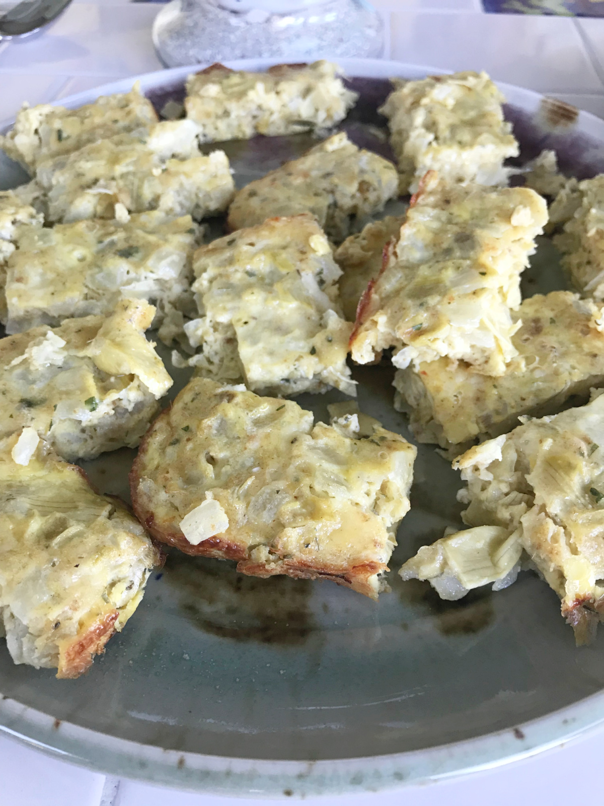 Cheesy artichoke squares on a platter.