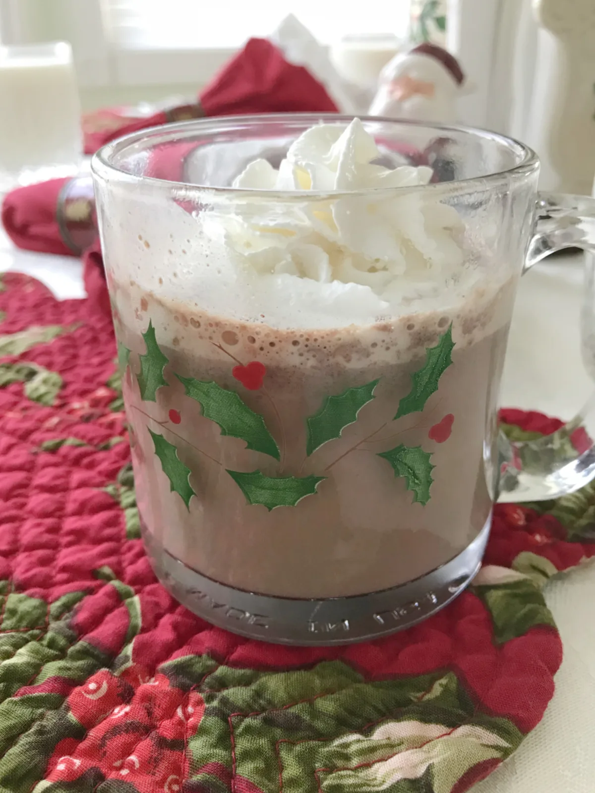 Hot chocolate topped with whipped cream in a Christmas mug.