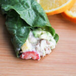 Tuna salad in a lettuce wrap on a cutting board.