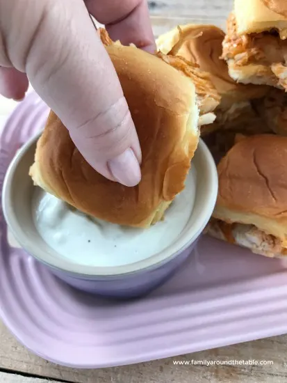 Easy Buffalo chicken sliders with homemade blue cheese dressing are sure to be a hit.