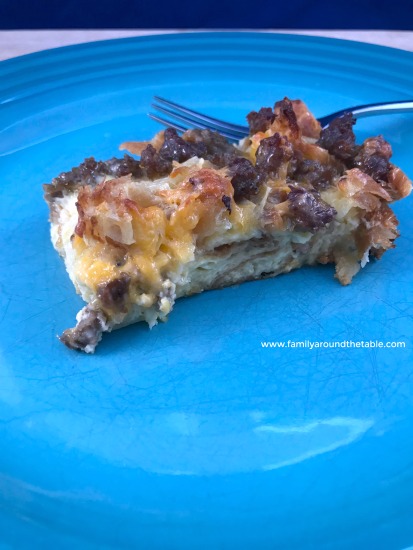 A slice of Maple Sausage Croissant Breakfast Casserole on a blue plate.