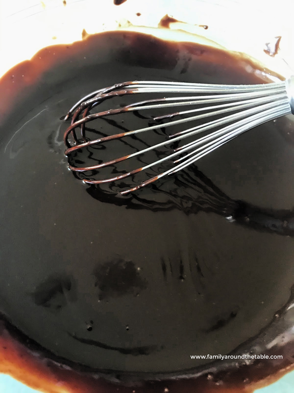 Ganache in a bowl with a whisk.