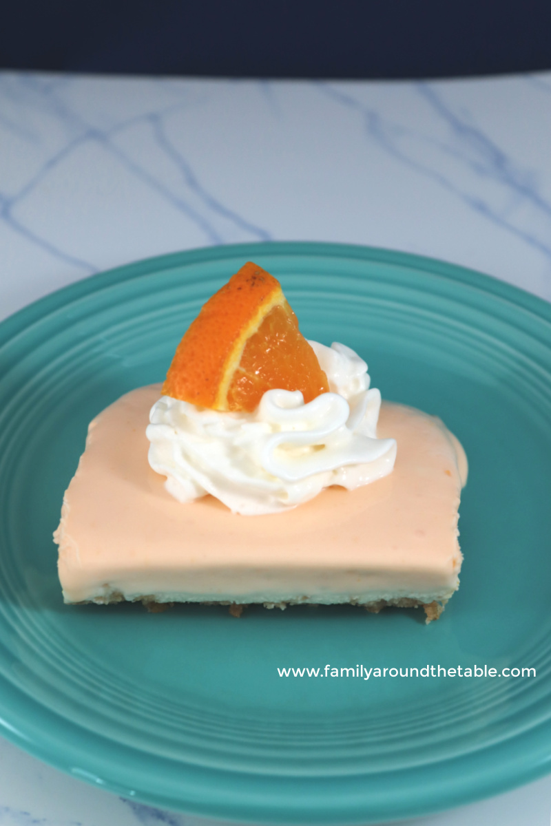 A square of no bake orange creamsicle bar on a teal plate.
