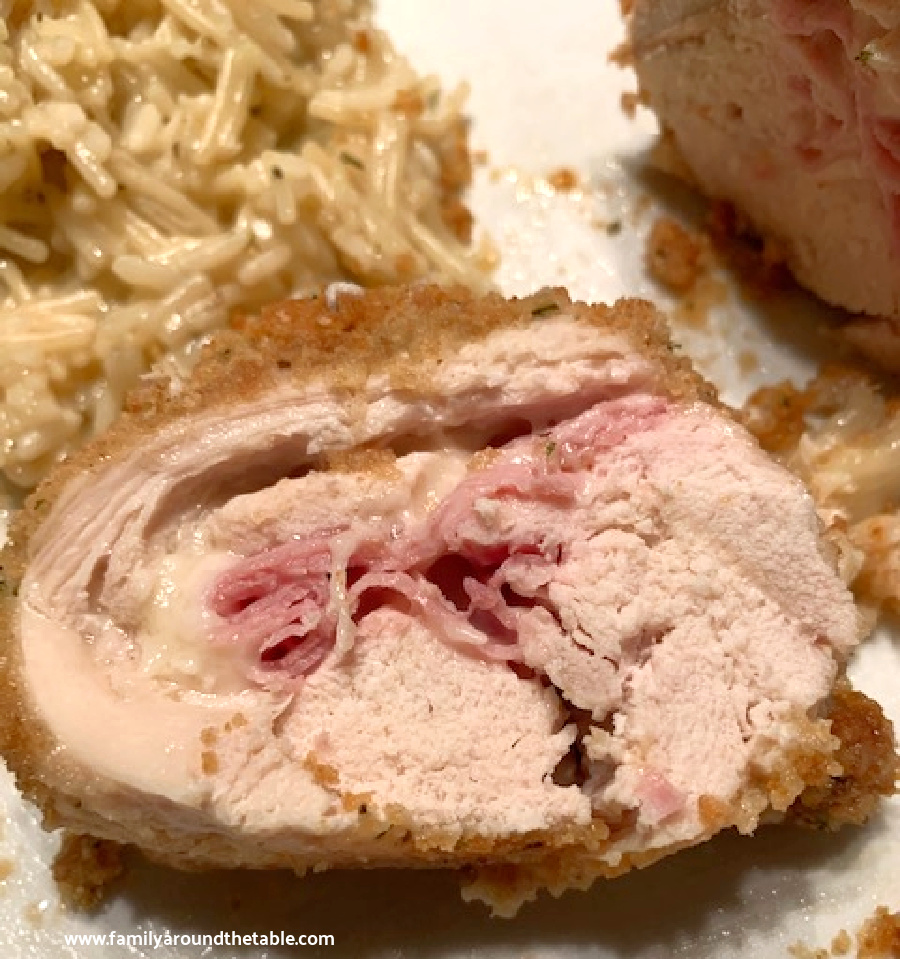 A slice of chicken cordon bleu on a plate, revealing the swirled ham and cheese.