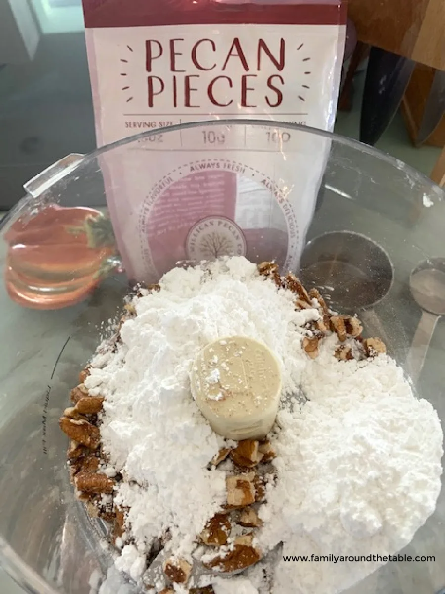 Pecans and confectioners' sugar in a food processor.