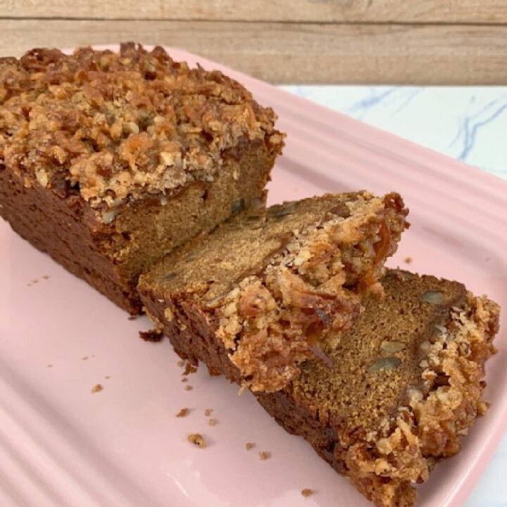 Sliced pecan persimmon bread on a pink platter.