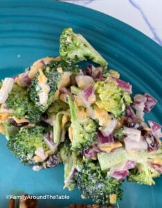 Broccoli salad on a blue plate.