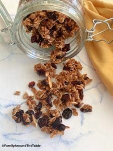 Almond Cranberry Granola spilling out of a glass jar.
