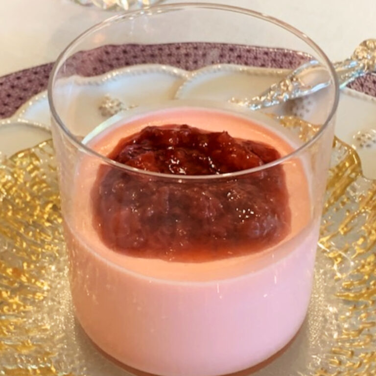 Panna Cotta in a glass with strawberry sauce.