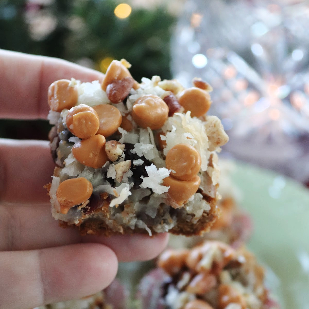 A gingerbread magic cookie bar being held.