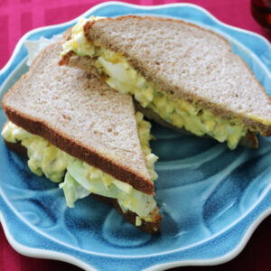 Egg salad sandwich on a blue plate.
