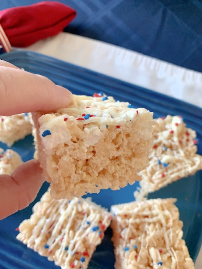 Side view of a Krispie treat with white chocolate drizzle and patriotic sprinkles.