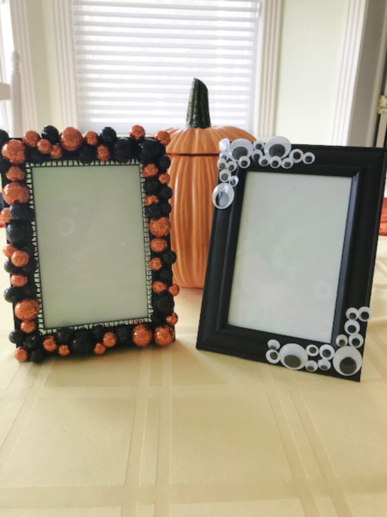 Two Halloween DIY picture frames on a yellow tablecloth.