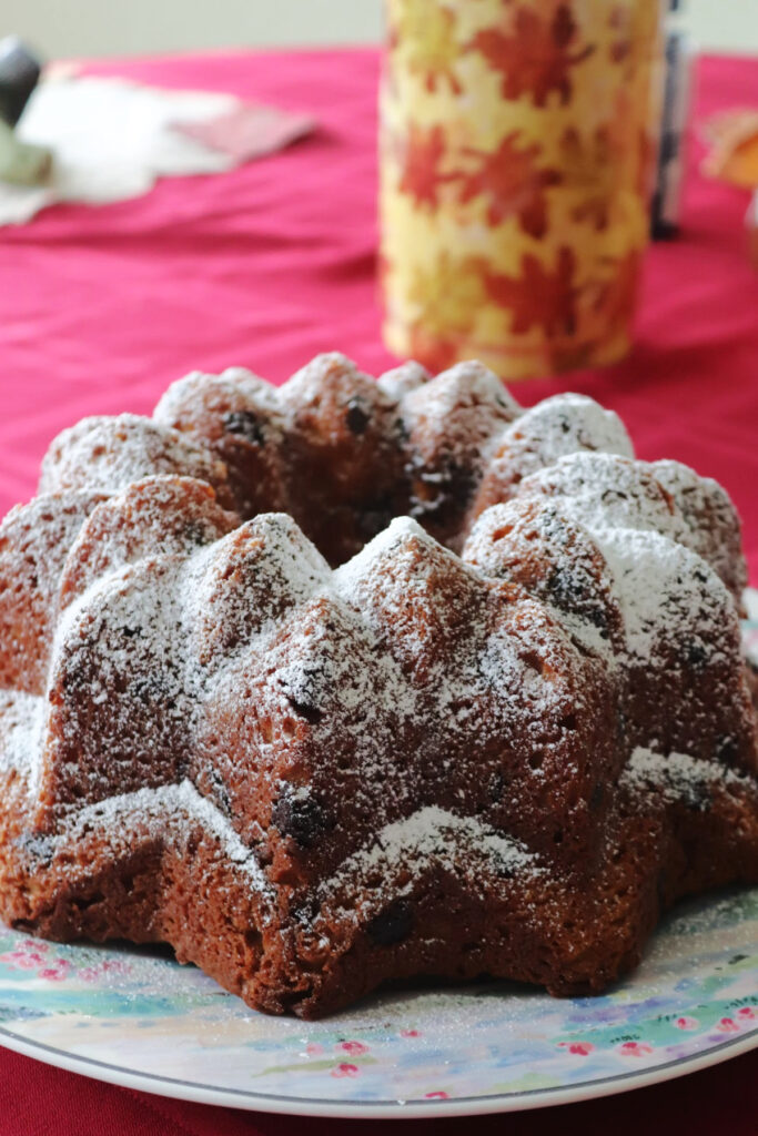 Powdered sugar dusted mounds Bundt cake on a plate.
