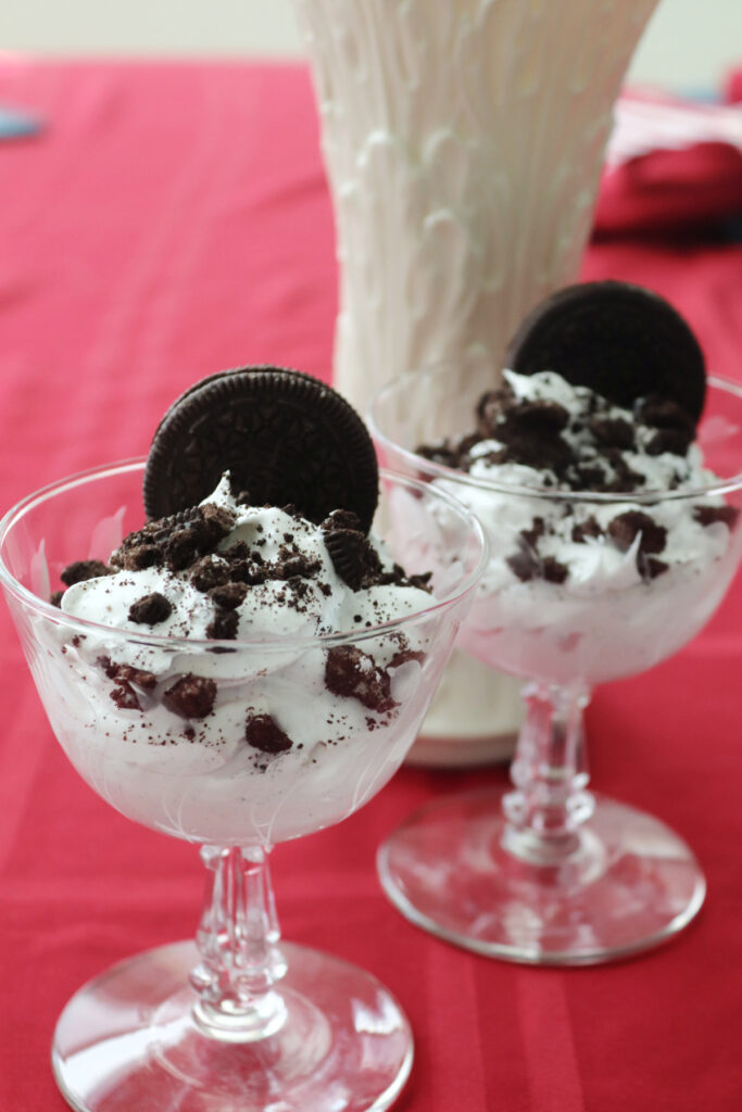 Two dessert cups with Oreo fluff, garnished with an Oreo.