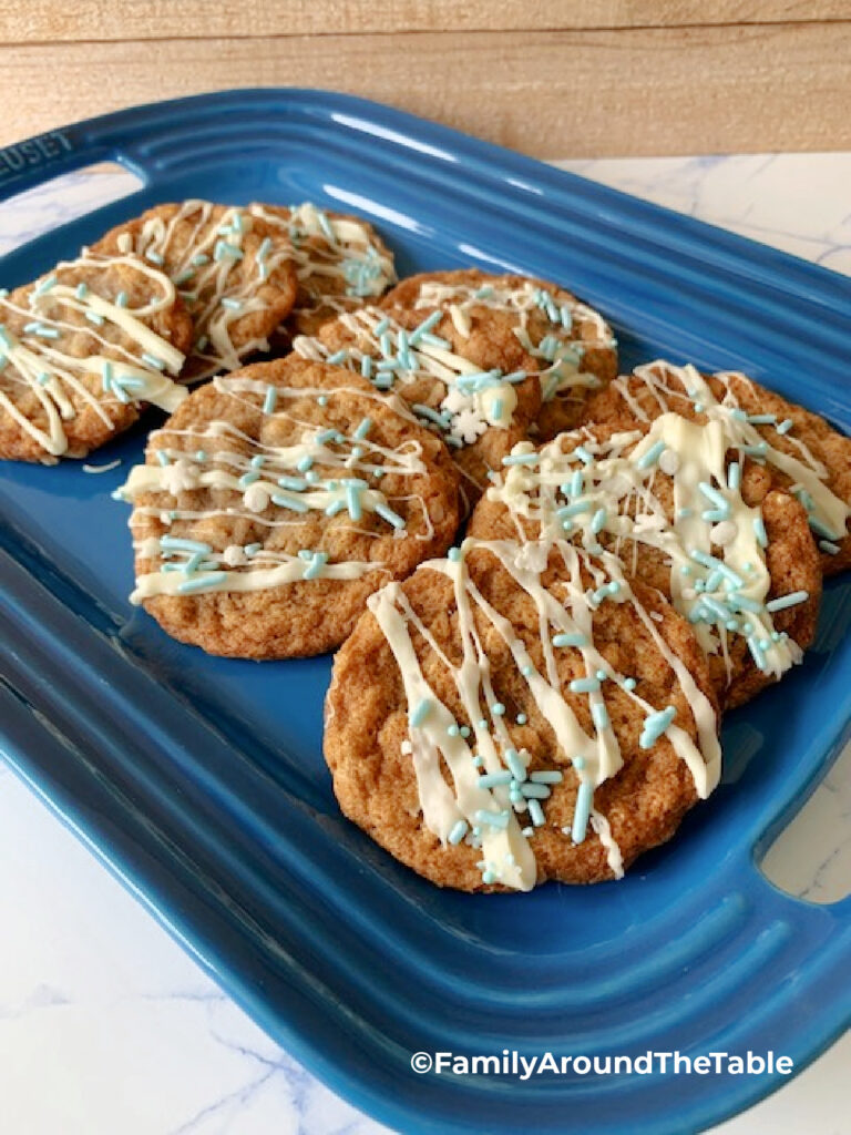 Decorated chewy oatmeal ginger cookies on a blue platter.