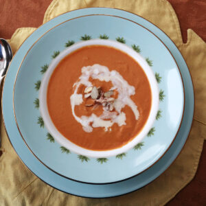 Overhead view of pumpkin crab bisque in a bowl set on a plate.