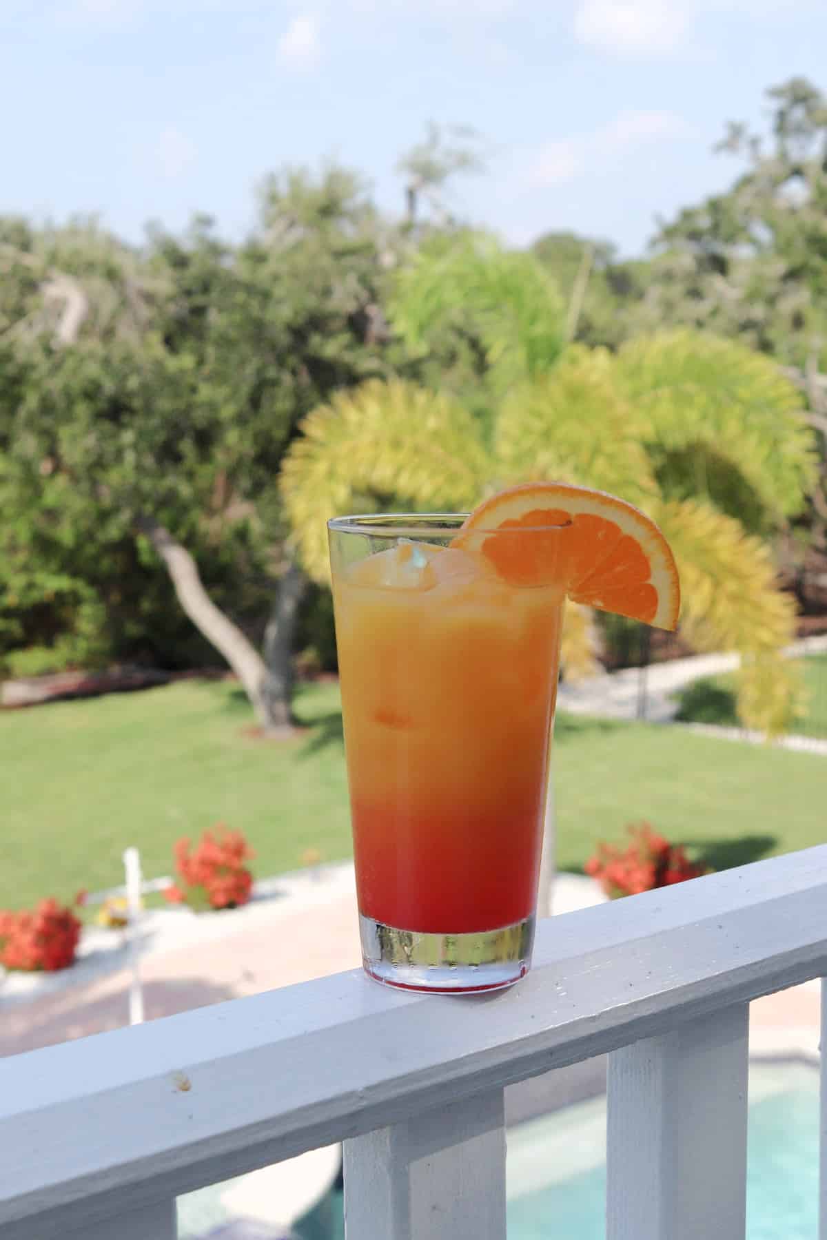 A fruity cocktail on a white railing.