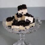 Pieces of White Chocolate Oreo Fudge stacked in a crystal candy dish.