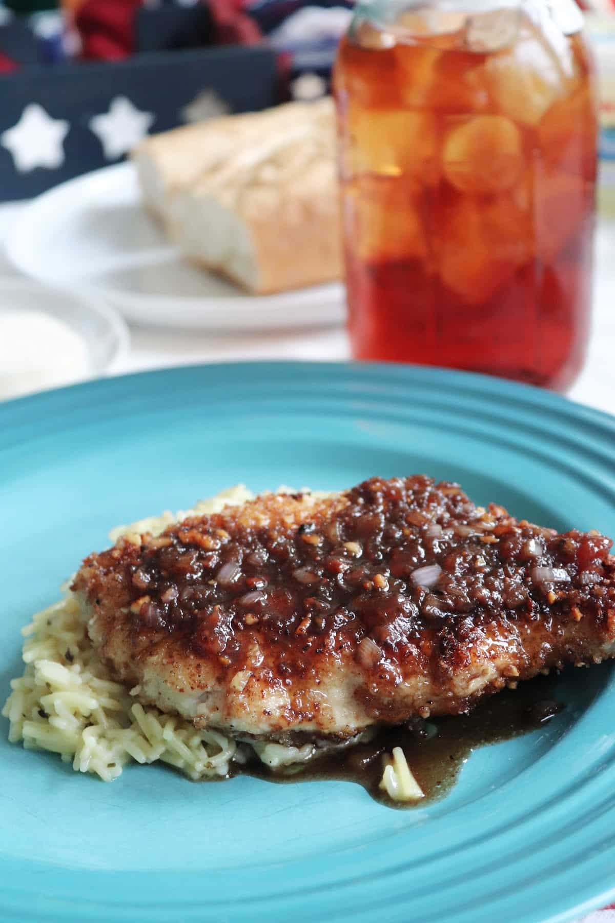 Crispy almond chicken with strawberry balsamic sauce on a blue plate.