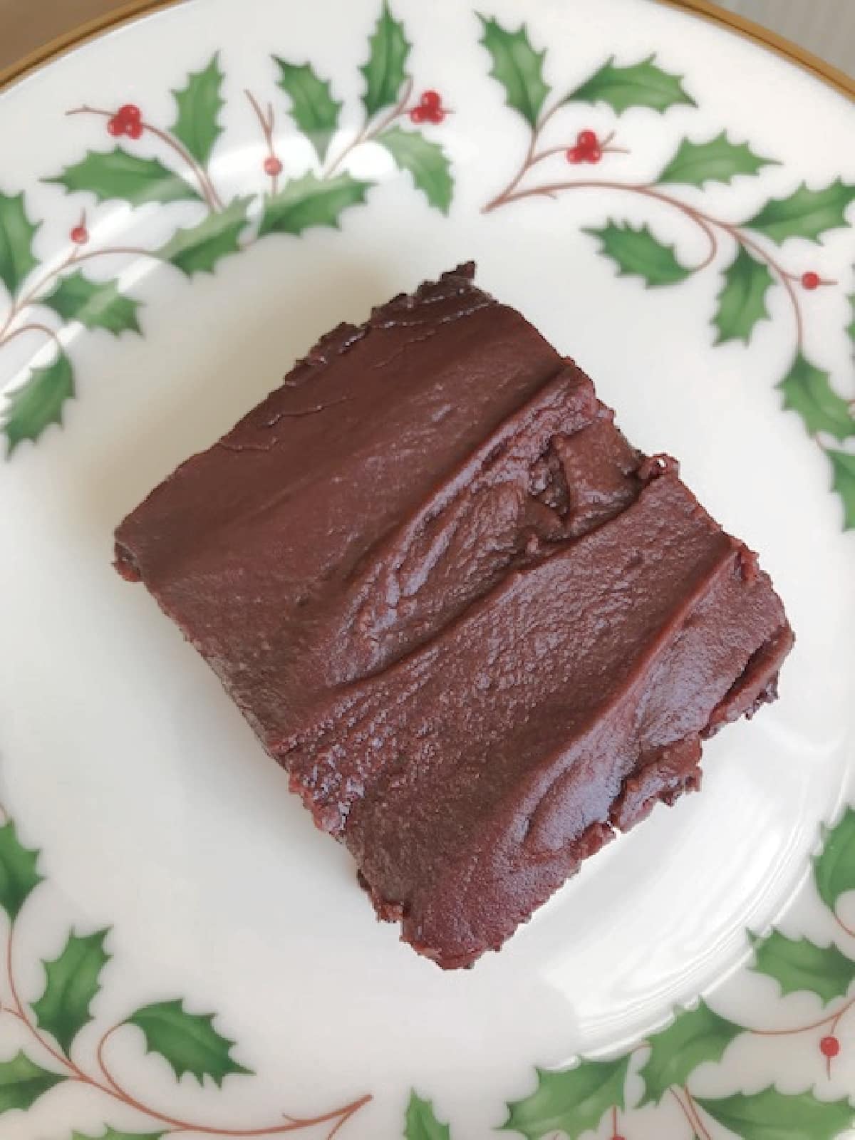 Overhead view of a frosted chocolate cherry bar on a Christmas plate.
