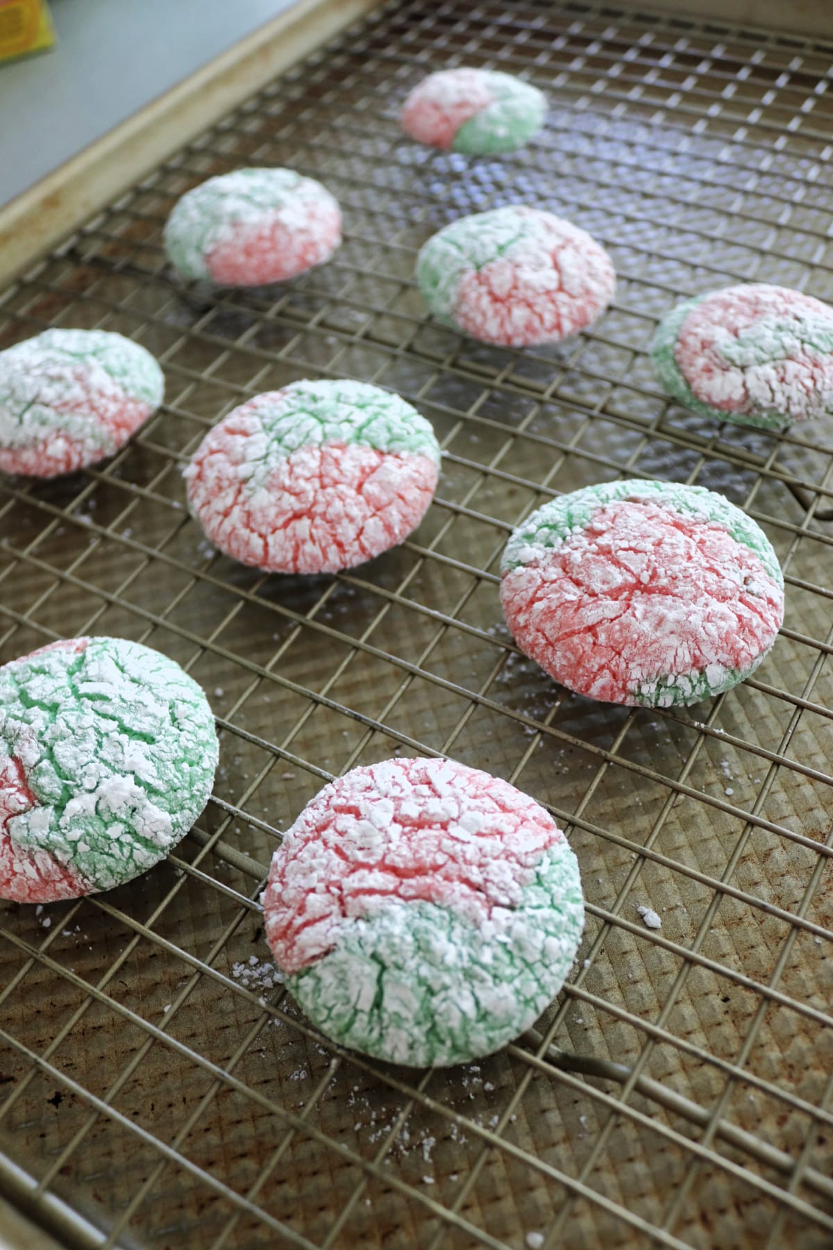 Christmas crinkle cookies on a cooling rack over a baking sheet.