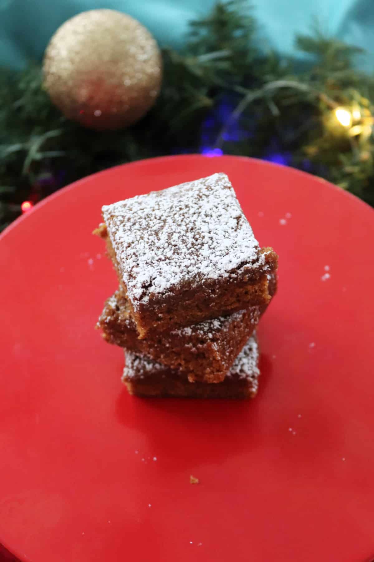 Gingerbread bars stacked on a red tray.