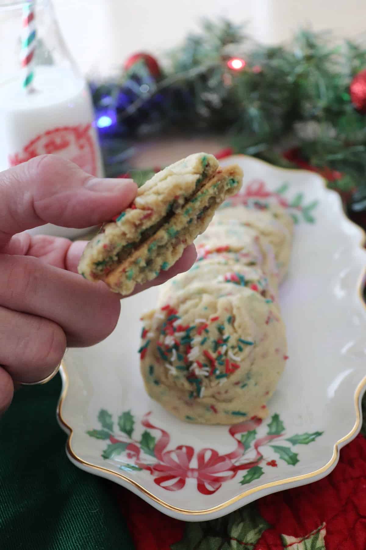 The inside of a vanilla pudding cookie being held over other pudding cookies.