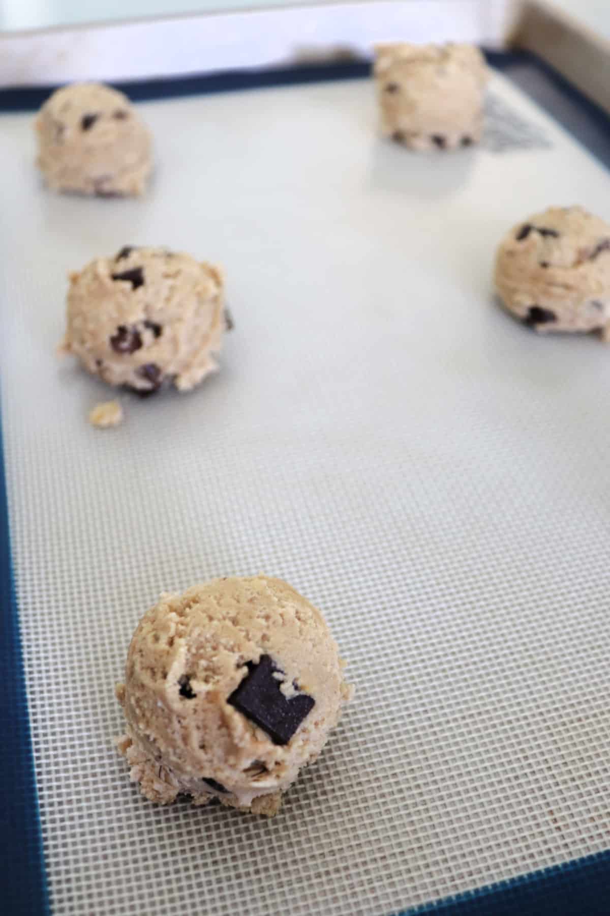 Cookie dough balls on a baking sheet.
