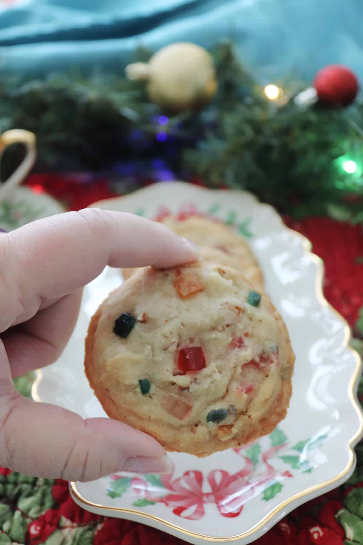A fruitcake cookie being held.