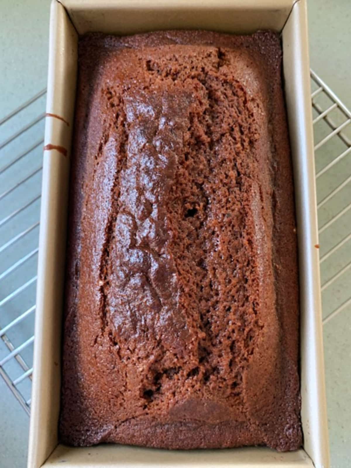 Overhead view of a whole gingerbread loaf in a baking pan.