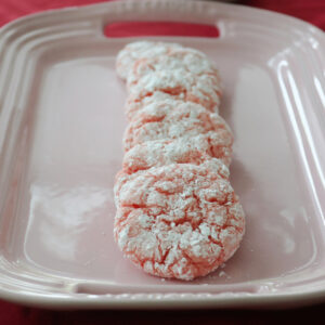 Pink strawberry crinkle cookies on a pink platter.