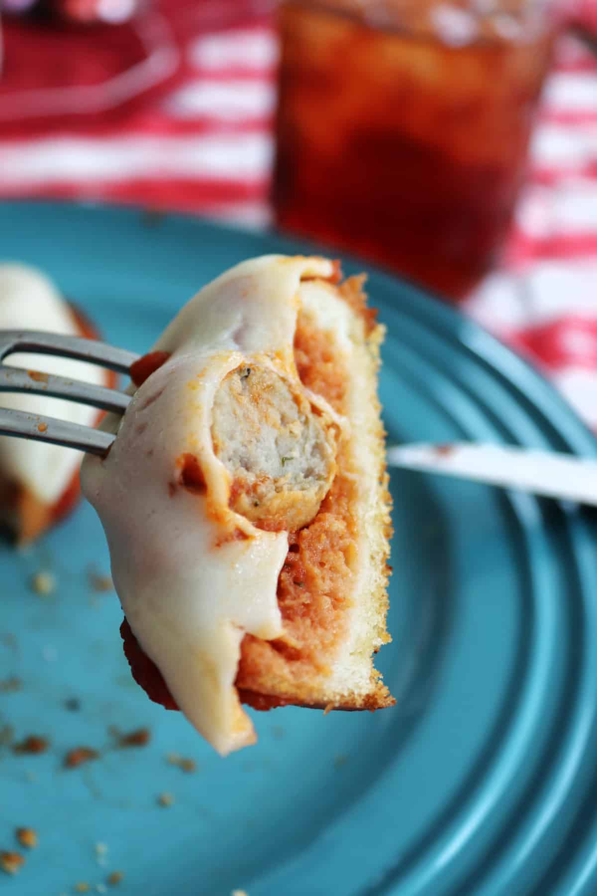 A piece of a meatball sandwich on a fork.