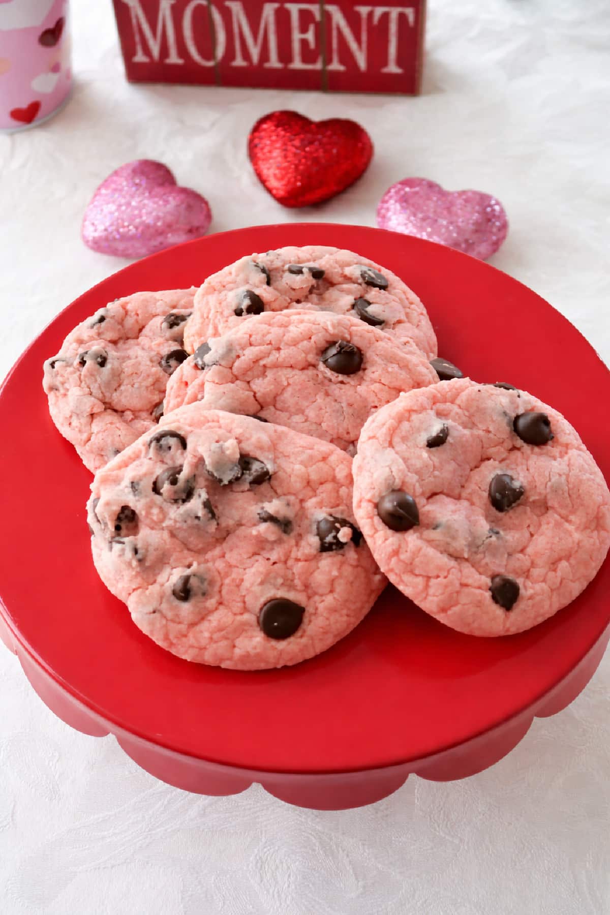 Overhead view of strawberry chocolate chip cookies on a red tray.