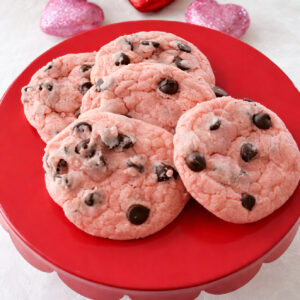 Chocolate chip strawberry cookies on a red cake plate.