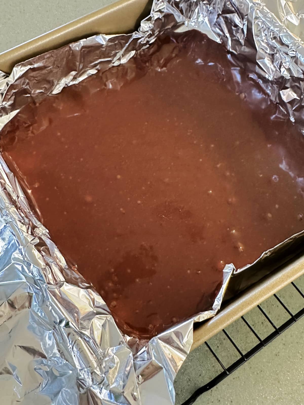 A foil lined pan with truffle mixture in it.