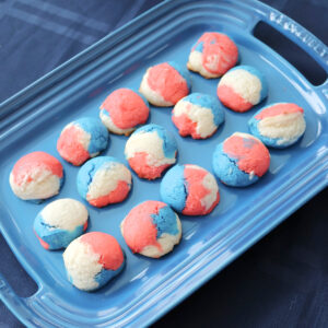 Red white and blue cookies on a blue platter.