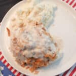 Overhead view of lazy chicken on a white plate with mashed potatoes.